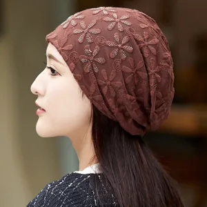Brown lace chemo hat with floral embroidery and rhinestone details, side view close up.