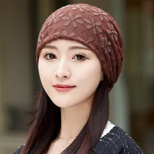 Close-up detail of the brown mesh chemo cap featuring delicate floral embroidery and sparkle.