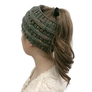 Dettaglio berretto con coda di cavallo in maglia verde scuro, cappello in lana calda.