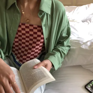 Gros plan détaillé d'un foulard en soie à carreaux tendance porté avec une chemise.