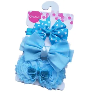 Vue détaillée de l'ensemble de bandeau bébé bleu avec nœuds, dentelle et jolis motifs.