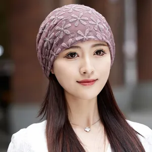 Detailed closeup of the elegant mauve floral lace chemo cap worn by model, soft breathable fit.