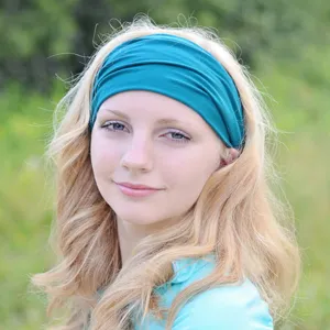 Close-up detail of the teal stretchy yoga headband worn by model, soft fabric design.