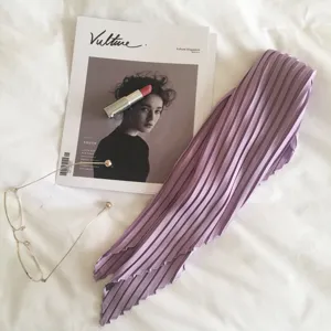 Detailed view of a purple pleated silk-feel neck scarf, elegant accessory for daily wear.