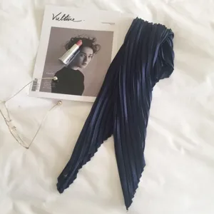 Detailed view of the elegant navy blue pleated scarf showing fine texture and versatile style.