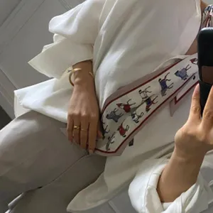 Detailansicht des eleganten schmalen Seidenschals mit stilvollem Reiterprint für Damen.