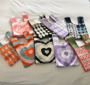 Detailansicht stilvoller Strick-Einkaufstaschen mit bunten Herz- und Mustermotiven.