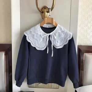 Detailansicht eines dunkelblauen Pullovers mit einem schönen weißen Spitzenkragen.