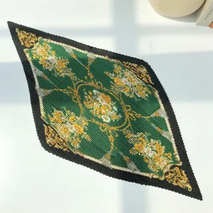 Detailed view of the pleated floral silk scarf with vintage chains and black border.