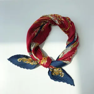 Pleated silk scarf detail, red and blue baroque chain print, elegant neckerchief accessory.