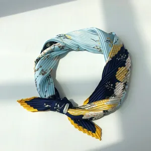 Detail view of the pleated floral imitation silk scarf highlighting exquisite texture and pattern.