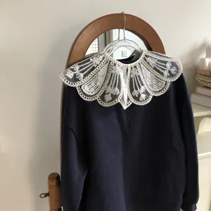 Detachable lace embroidered fake collar with dark blue sweatshirt, versatile spring accessory.