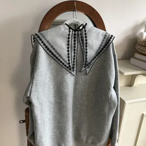 Versatile hollow embroidered mesh false collar paired with grey sweatshirt, chic spring summer style.