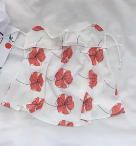 Detail view of white summer sun protection face mask with red floral print and ear loops.