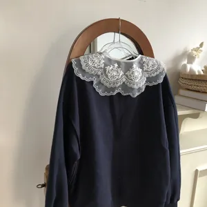 Detail view of a stylish dark blue sweatshirt featuring a delicate lace embroidered doll collar.