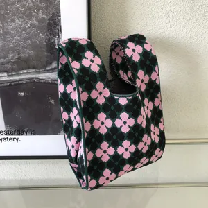Nahaufnahme der gestrickten Blumentasche mit einem süßen rosa und schwarzen Blumenmuster.