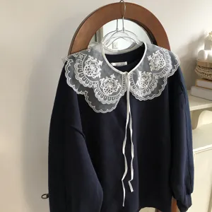 Close-up detail of a dark blue sweatshirt paired with a white lace embroidered fake collar.
