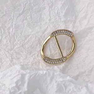 Detailaufnahme der goldenen Metall Strass Schal Schnalle mit elegantem glänzendem Design.