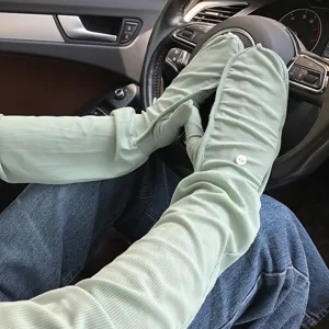Detailansicht hellgrüner gerippter Sonnenschutzärmel beim Autofahren im Innenbereich.