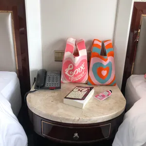 Detailansicht der modischen Strick-Tasche mit bunten Herz-Mustern, ideal für Frühling und Sommer.