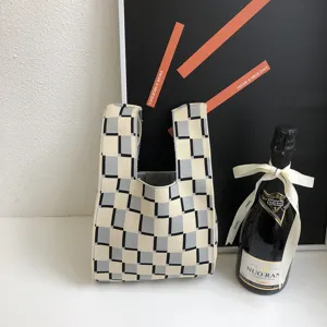 Detailansicht einer schicken karierten Strick-Tasche im stilvollen Grau-Schwarz-Design.