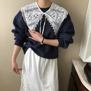 Detailaufnahme eines stilvollen, abnehmbaren Spitzenkragens kombiniert mit einem Pullover.