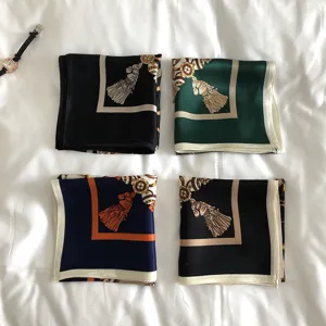 Silk square scarf featuring elegant chain and tassel print, detailed fabric close-up view