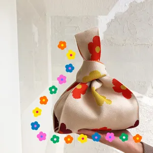 Strick-Knotentasche Detailansicht mit bunten Blumenmustern und weichem Handgelenkgriff Design.