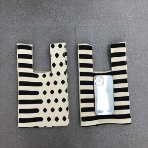 Elegante schwarz-weisse gepunktete Stricktasche, modische Handtasche fur Damen.
