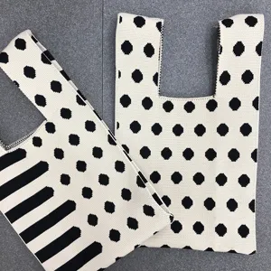 Detailansicht der schwarz-weißen Strick-Handtasche mit Punkten, die Textur und Muster zeigt.
