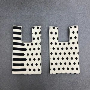 Elegante schwarz-weiße Stricktasche mit Punkten und Streifen für modische Damen im Alltag.