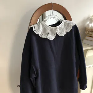 Exquisite lace embroidered doll collar detail with delicate hollowed-out floral pattern.