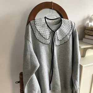 Grey sweatshirt featuring a layered polka dot sheer lace scalloped collar and black tie details.
