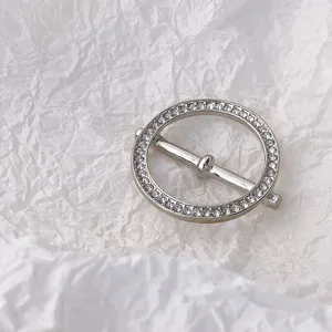 Detailaufnahme einer funkelnden Strass-Seidenschalschnalle, elegantes Metallaccessoire.