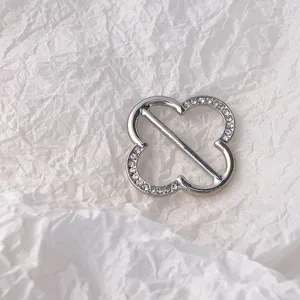 Nahaufnahme einer eleganten silbernen Strass-Kleeblatt-Schalschnalle, glänzendes Detail.
