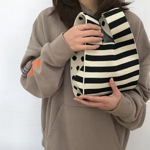 Nahaufnahme Detail einer schicken schwarz-weißen gestrickten Tasche in der Hand, modern.