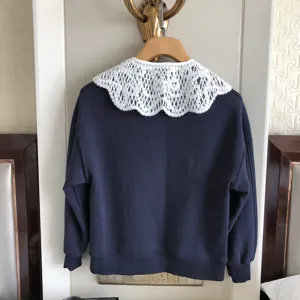 Detailansicht des dunkelblauen Sweatshirts mit weißem Spitzen-Ausschnitt und Kragen.