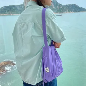 Detailansicht der stilvollen lila plissierten Strick-Umhängetasche, lässiges Modeaccessoire.