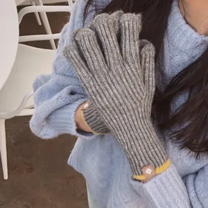 Cozy gray ribbed knit gloves for women and men, featuring warm winter wool and stylish yellow trim.