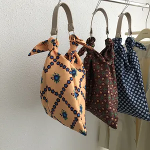Detailansicht stilvoller gemusterter Stoffhandtaschen, die an einer Kleiderstange hängen.