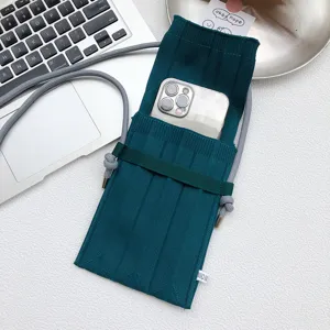 Grüne Strick-Handytasche Umhängetasche Mini Stricktasche Detailansicht mit Riemen.