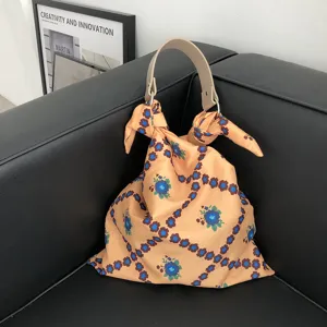Detailansicht der stilvollen blumigen Stofftasche mit elegantem hellem Griff und Knoten.