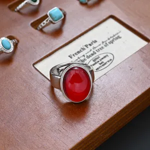 Close-up detail of a vintage style red stone ring displayed on a wooden jewelry tray.