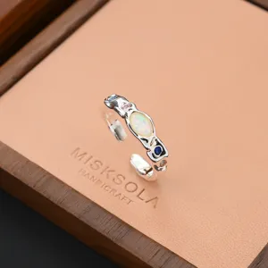 Detailed shot of an irregular molten style silver ring inlaid with opal and colorful zircon.
