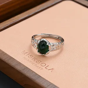 Close-up detail of vintage style open ring with green synthetic turquoise and carved silver band.