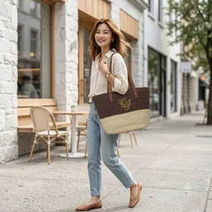 Detail view of two-tone woven tote bag with custom CJ monogram and sturdy shoulder straps.