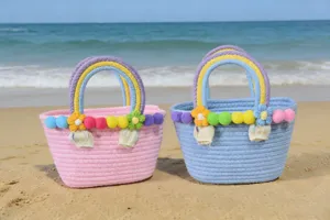 Detailed shot of handmade woven beach bags with colorful pom-pom and rainbow handles.