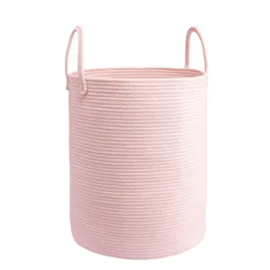 Grand panier à linge rond en corde de coton rose avec poignées pour vêtements et jouets.
