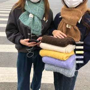 Detailansicht von flauschigen Winter-Strickschals in bunten Bonbonfarben im Freien.