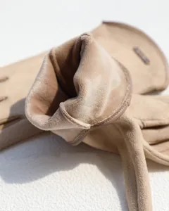Close-up detail of soft faux suede winter gloves featuring cozy warm plush interior lining.